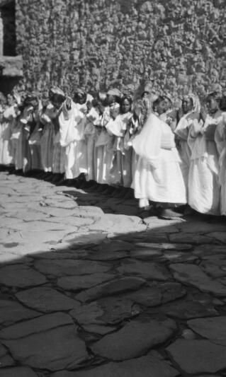 Group of Berber women dancers lined up in front of a wall. Telouet, 13th January 1936.