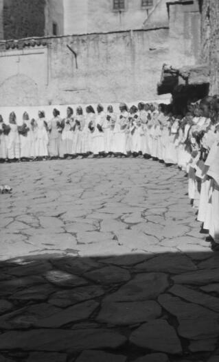 Twenty or so Berber Dancers holding hands and arranged in a semi circle in a courtyard.Telouet, 13th January 1936.