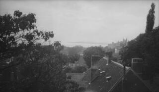 A view across rooftops to a lake. On the right are the cathedral's twin spires. Location unknown.