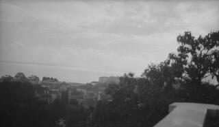 View across rooftops to a lake, location unknown.