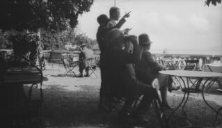 David Lloyd George and others in his party looking at the scenery from a hotel or restaurant garden.