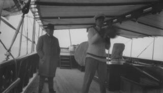 David & Gwilym Lloyd George on deck, but under an awning, on the 'Sabrina.' Gwilym is amusing himself with a punchbag.