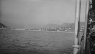 Heavily developed coastline with hills behind as seen from the sea.