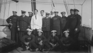 Group portrait of the captain and crew of the yacht 'Sabrina' arranged in rows on the deck of the vessel.