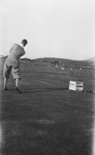 Dyn yn chwarae golff