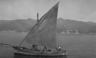 A wooden fishing boat with lateen sail photographed from the deck of 'Sabrina'. In the distance can be seen Santa Margherita Ligure, Italy.