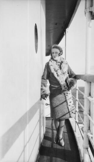 Young lady in a fur trimmed coat photographed aboard a ship.