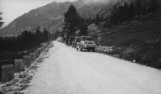 Three cars parked alongside an alpine road including YF 5930. These are believed to be Lloyd George's entourage. Concrete bollards line the road on the left hand side.