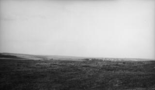 A flat, almost featureless plain with a village centre right. Reminiscent of the Picardy landscape this is possibly the site of a WW1 battle.