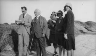 Gwilym Lloyd George consults a map, David, Edna & Megan Lloyd George along with Mrs Sylvester are looking into the distance. All are standing on a road.