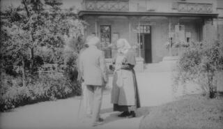 Lloyd George in the company of Herr Luz conversing with a nun. A J Sylvester writes on p179 of 'The Real Lloyd George' "In the evening L.G. and some of the party accompanied Herr Luz to the Convent which adjoined the hotel grounds in Freudenstadt. Herr Luz is identifiable by reference to other photos of the entourage in Freudenstadt.