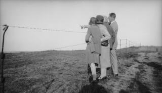 Four members of the Lloyd George family standing near a barbed wire fence and looking into the distance.