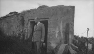 Gwilym Lloyd George in the doorway of a concrtete pillbox. On page 187 of 'The Real Lloyd George' A J Sylvester writes "We motored rapidly through Belgium and passed over the battlefields again,this time visiting dug-outs which Gwilym had occupied during the war..." This may be one such dug-out.