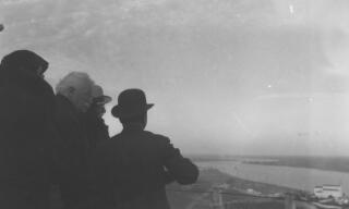 David Lloyd George and others view a wide river from a vantage point.