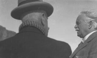 A windswept David Lloyd George (seen in profile) in conversation with his guide.