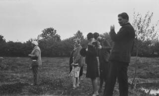 David Lloyd George and members of his Secreteriat in a field and looking at something to the left of the photo.