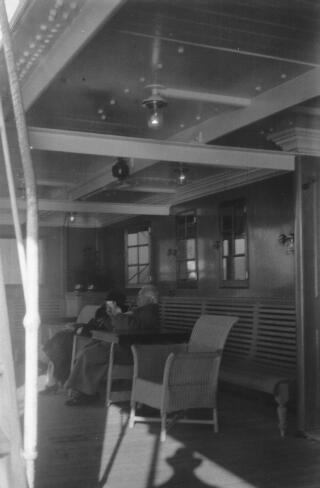 David & Margaret Lloyd George well wrapped up sitting in chairs on the deck of a ship.