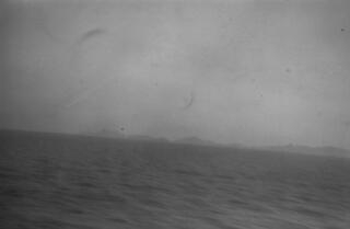 A view of a distant coast taken, presumably, from the deck of "Sabrina"