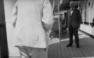 Dyn mewn gwisg wen drofannol yn tynnu llun Lloyd George
